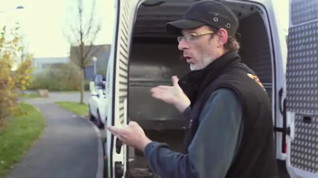 Un chauffeur-collecteur explique son métier devant sa camionnette