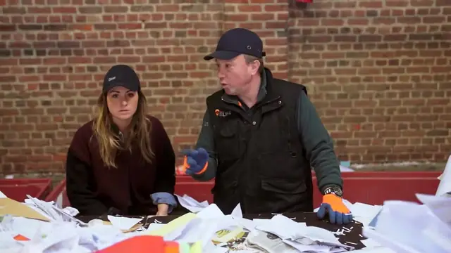 L'éco-reporter et un trieur devant une table de tri remplie de papier