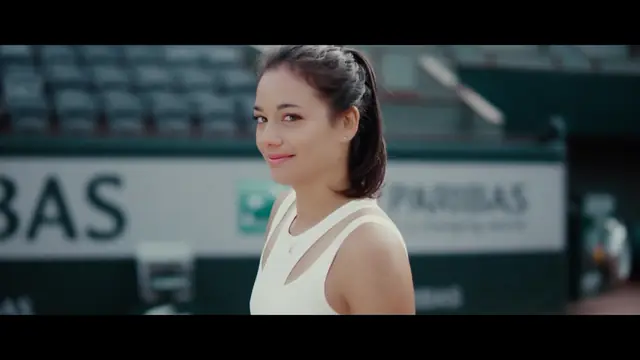 La joueuse de tennis Alizé Lim sourit sur le court, devant les tribunes de Roland-Garros